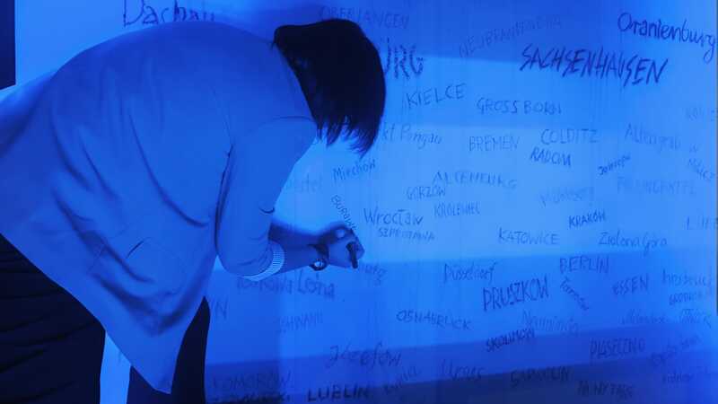 Nazwa "Burgweide" wpisywana przez Kamillę Jasińską na ścianie pamięci w Muzeum Dulag 121 w Pruszkowie. Fot. Iwona Wawrzkowicz / IPN Wrocław