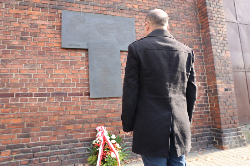 Dyrektor Oddziału IPN we Wrocławiu dr hab. Kamil Dworaczek przed tablicą Profesorów krakowskich na murze więzienia przy ul. Kleczkowskiej, 6 listopada 2024 roku. Fot. Maciej Parysek / IPN Wrocław