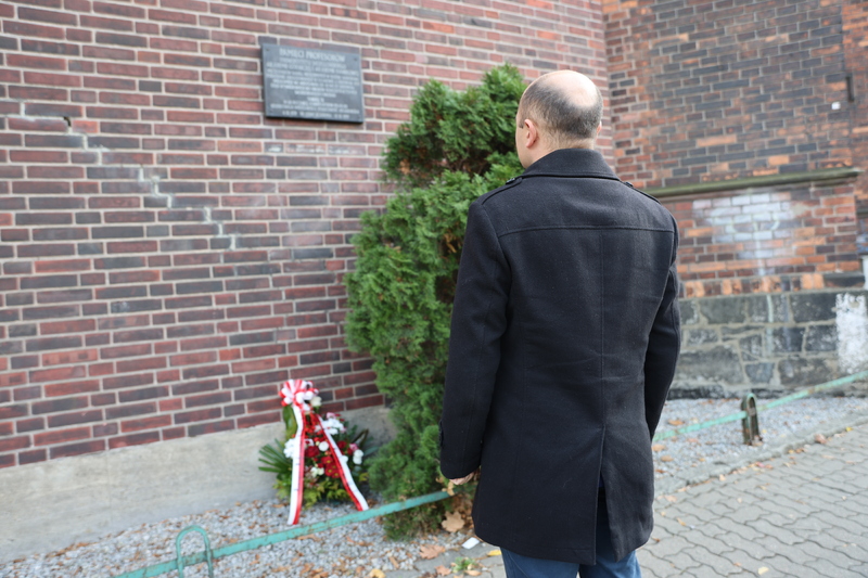 Dyrektor Oddziału IPN we Wrocławiu dr hab. Kamil Dworaczek przed tablicą Profesorów krakowskich na murze aresztu śledczego przy ul. Sądowej, 6 listopada 2024 roku. Fot. Maciej Parysek / IPN Wrocław