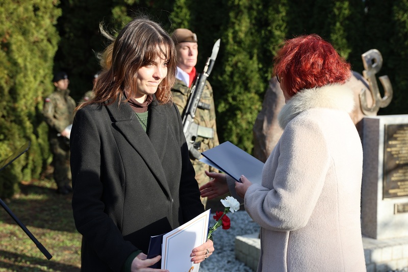 Dyrektor IV LO Małgorzata Górny przekazująca uczniom pamiątkowy akt deklaracji objęcia pomnika opieką szkoły.  Fot. Maciej Parysek / IPN Wrocław