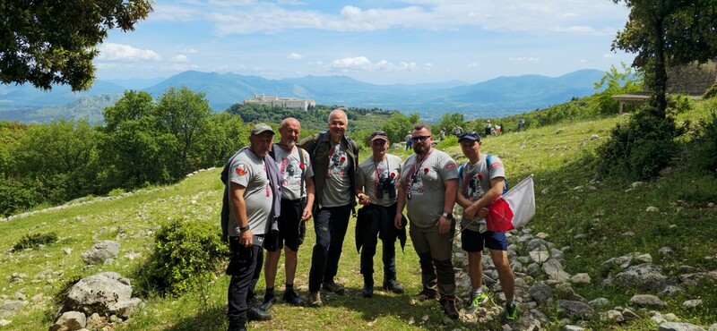 Grupka motocyklistów z komandorem Pawłem Krupą (drugi od prawej) i przewodnikiem Pino Valente (trzeci od lewej) przy podejściu do słynnego „Domku Doktora”. W tle widoczny klasztor na Monte Cassino.