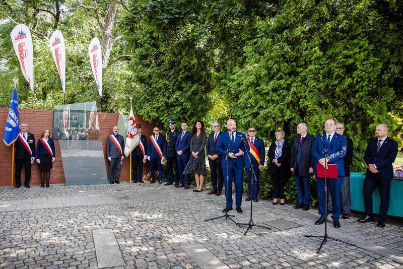 W tle przemawiający przy mikrofonie prezydent Wrocławia Jacek Sutryk