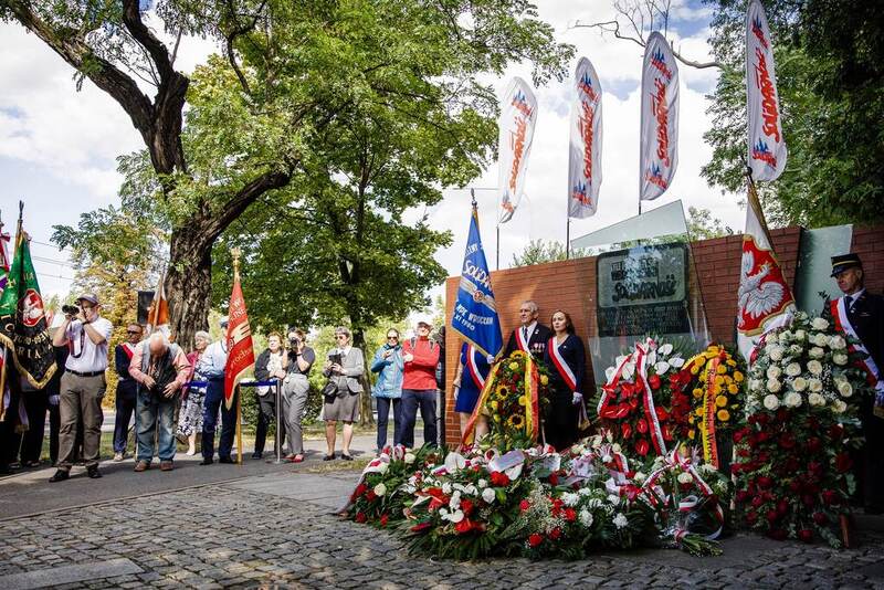 Na zdjęciu tablica tuż po uroczystości oraz wszystkie wiązanki kwiatów