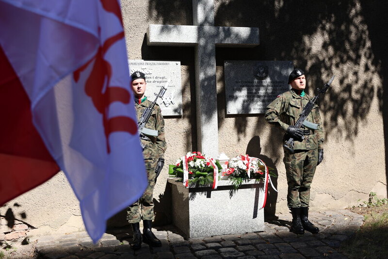 Zdjęcie na tablicę pod kościołem pod którą przed chwilą zostały złożone kwiaty