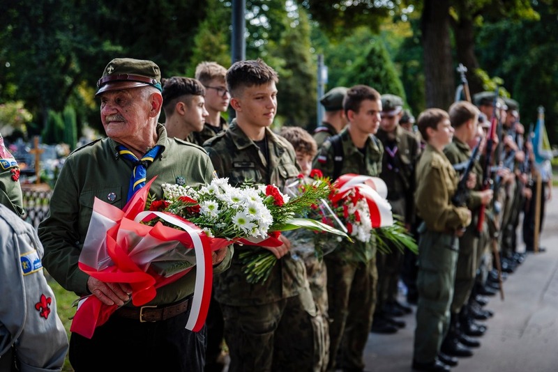 Na zdjęciu harcerze z wiązankami kwiatów
