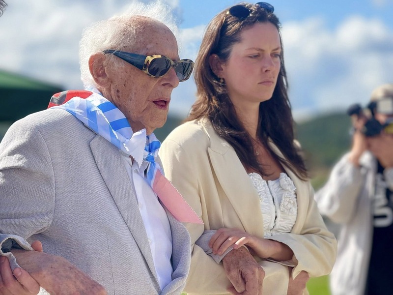 Zdjęcie przedstawia ponad 100 - letniego byłego więźnia obozu, podczas uroczystości składania kwiatów