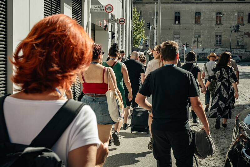 Zdjęcie przedstawia grupę osób, które idą ulicami Wrocławia w trakcie spaceru