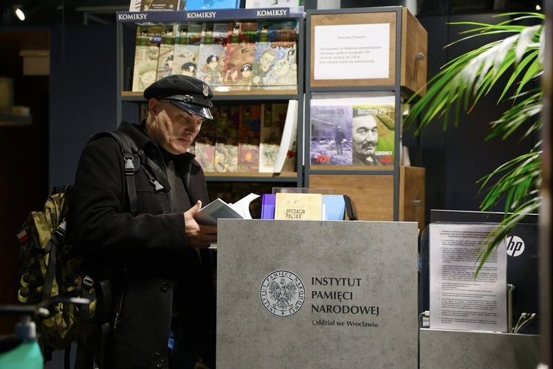 na zdjęciu mężczyzna stojący przy stoisku z książkami