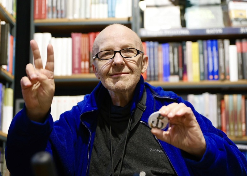 Mężczyzna zadowolony pokazujący znaczek, który dostał w księgarni