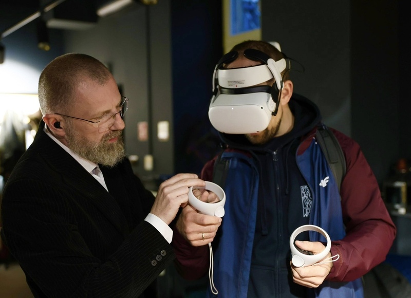 na zdjęciu z lewej Artur Cieślik z prawej mężczyzna, który zakłada okulary VR