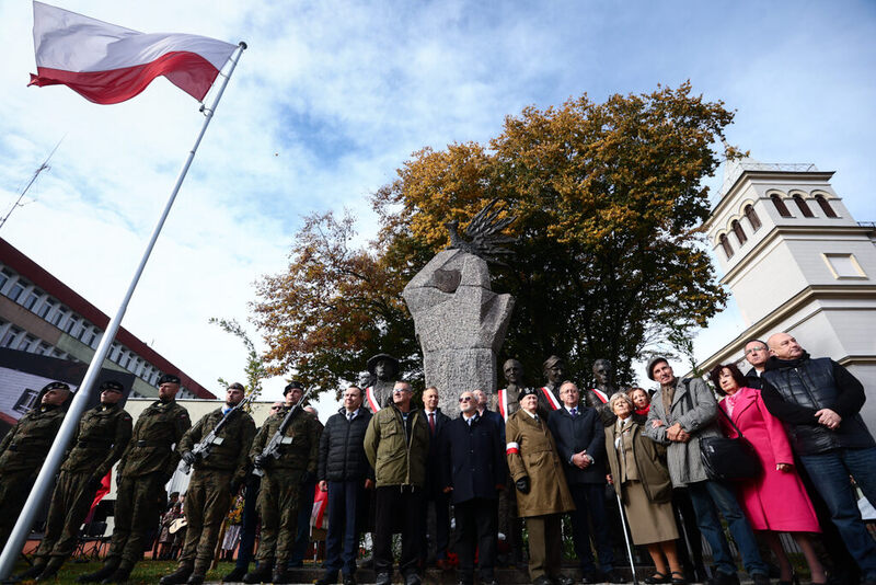Zdjęcie pamiątkowe wszystkich uczestników wydarzenia w tle pomnik