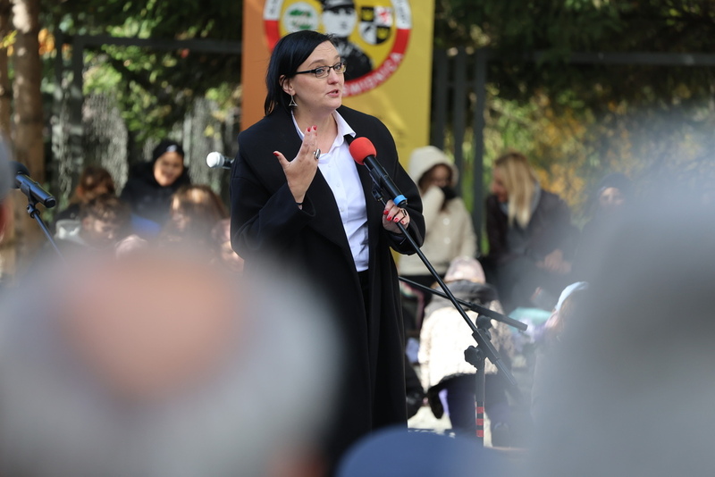 zdjęcie przedstawia Kamille Jasińską, stojącą przy mikrofonie w trakcie przemowy