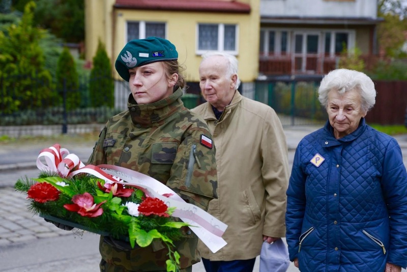 na zdjęciu moment składania kwiatów, na pierwszym planie żołnierz trzymający wiążankę