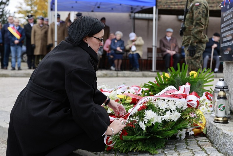 na zdjęciu Kamilla Jasińska która składa kwiaty pod obeliskiem
