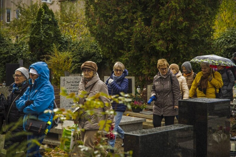 na zdjęciu grupa osób w trakcie zwiedzania między nagrobkami