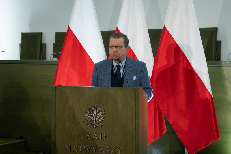 stojący przy mównicy •	Dr Krzysztof Łagojda