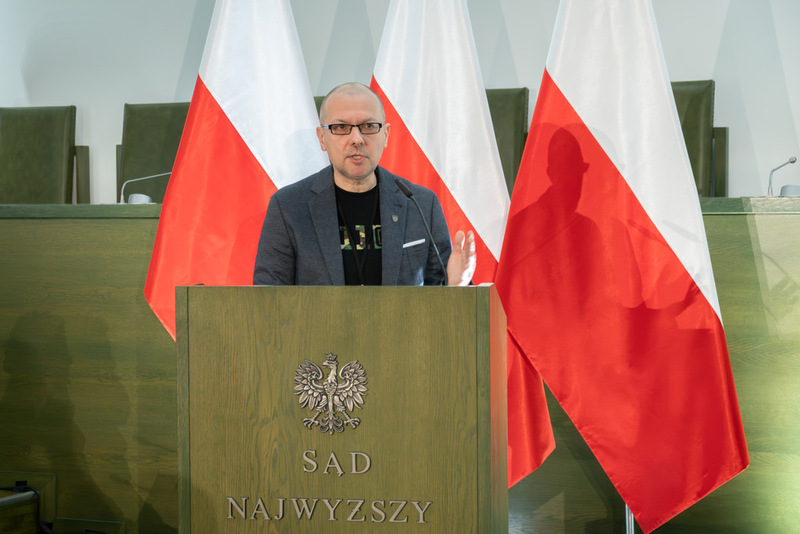 stojący przy mównicy •	Dr hab. Tomasz Balbus