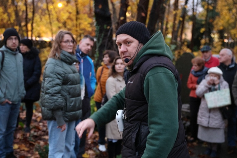 na pierwszym planie przewodnik mówiący do ludzi