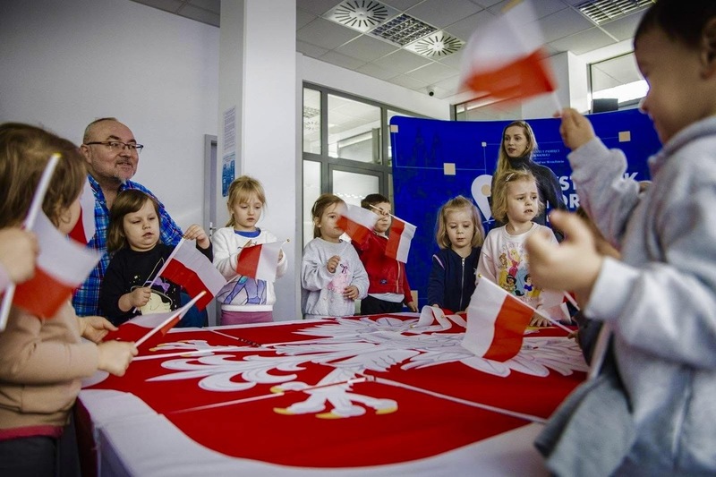 na zdjęciu duży obraz białego orła, po bokach dzieci w trakcie zajęć