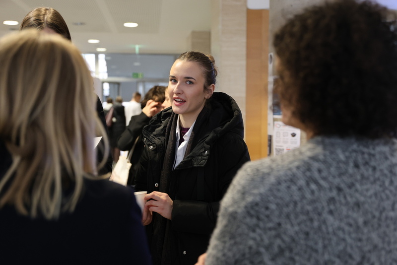 zdjęcie przedstawia kobietę, która stoi przy stoisku IPN i rozmawia z pracownikami