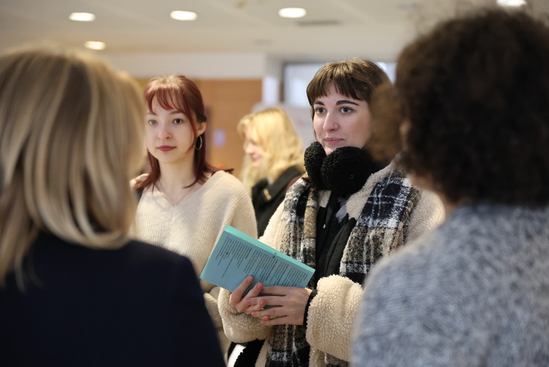 zdjęcie przedstawia kobietę, która stoi przy stoisku IPN i rozmawia z pracownikami