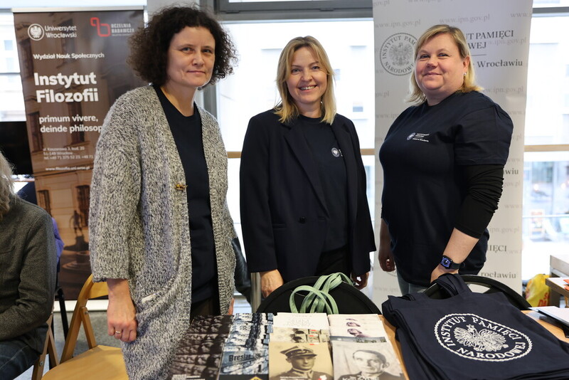 na zdjęciu trzy pracownice IPN, które stoją przy stoisku