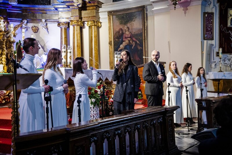 zdjęcie pokazuje fragment koncertu, przy ołtarzu stoją śpiewające ubrane w białe szaty kobiety