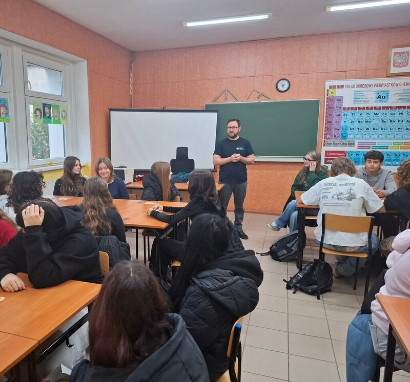 Przed uczniami na środku stali stoi Grzegorz Kowal i przemawia.