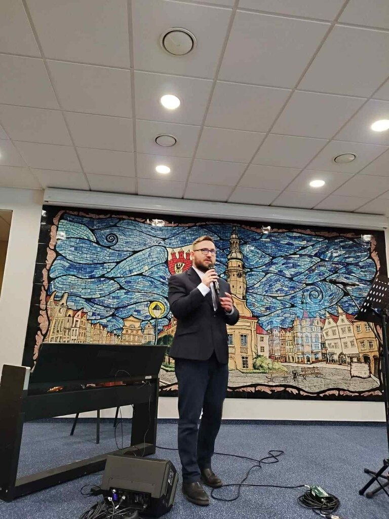 zdjęcie pokazuje scenę. Na scenie stoi Grzegorz Kowal