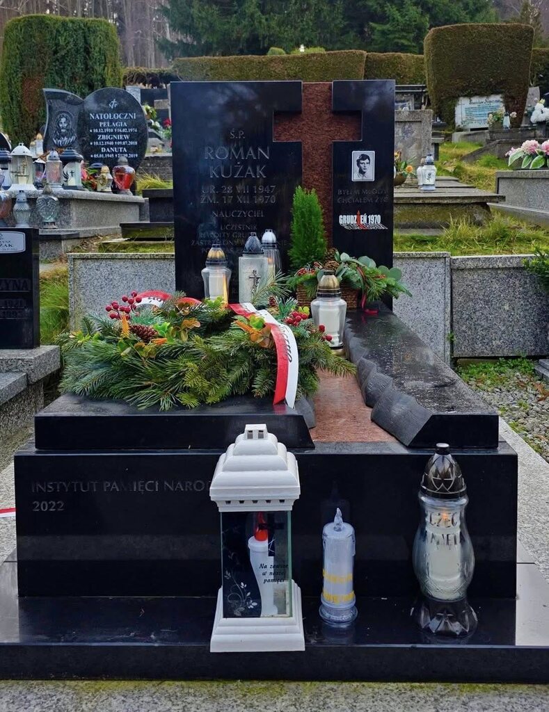 zdjęcie pokazuje grób Kużaka na grobie wiązanki kwiatów