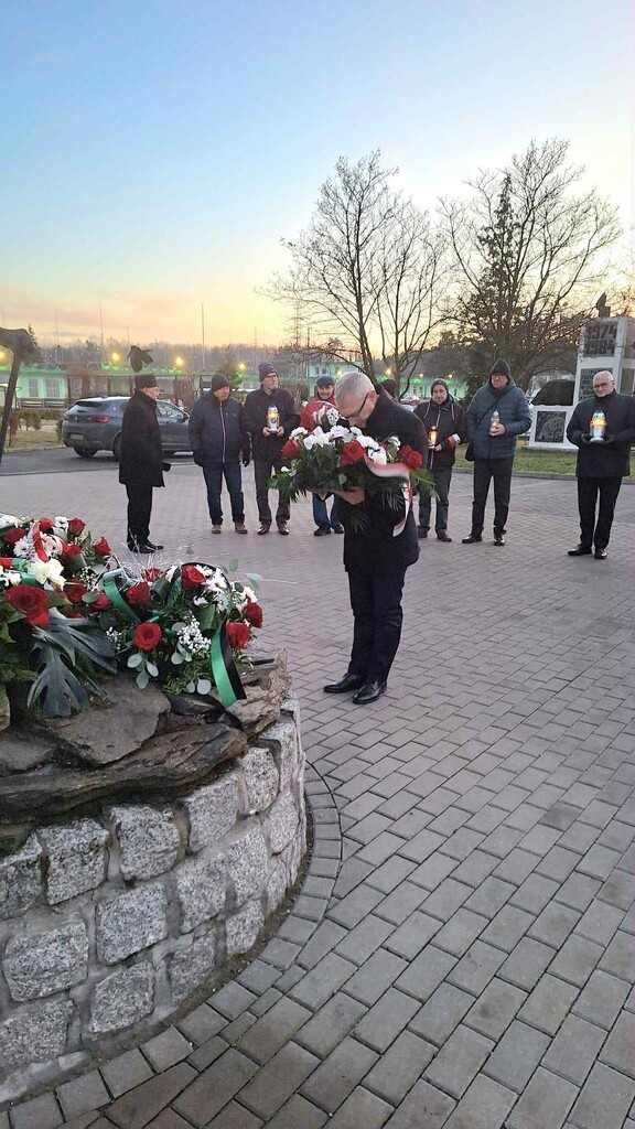na zdjęciu moment skladnia kwiatów pod obeliskiem