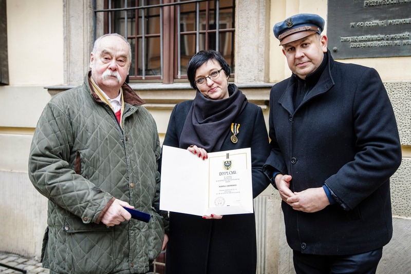 na zdjęciu trzy osoby - w środku Kamilla Jasińska trzymająca wyróżnienie