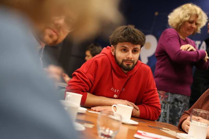 siedzący ludzie przy stole grający w grę