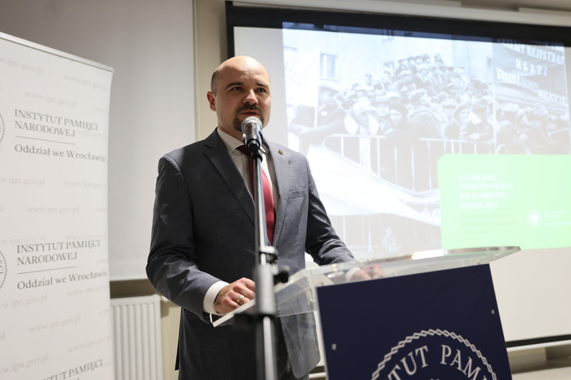 na zdjęciu dyrektor IPN Wrocław Kamil Dworaczek przy mównicy