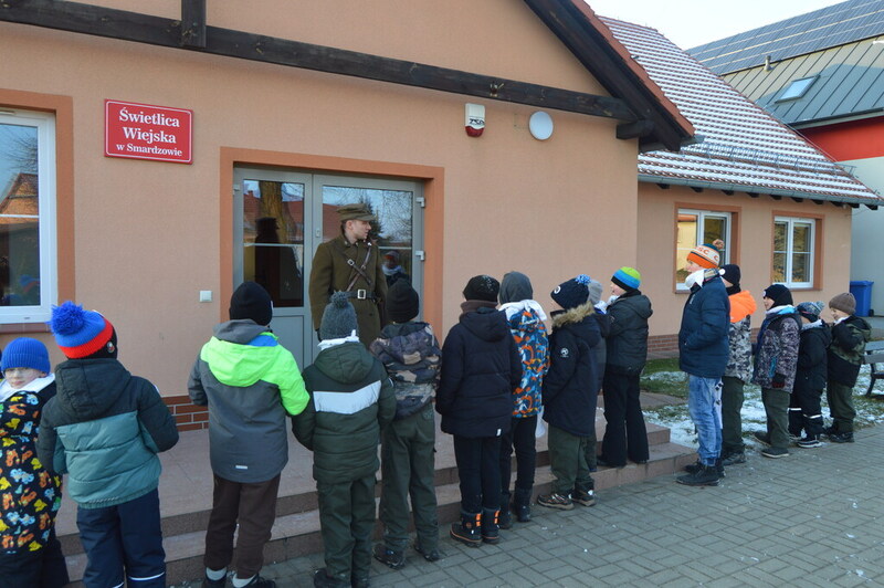 zdjęcie wykonane na zewnątrz, zbiórka przed budynkiem, na środku Mikołaj Sokalski