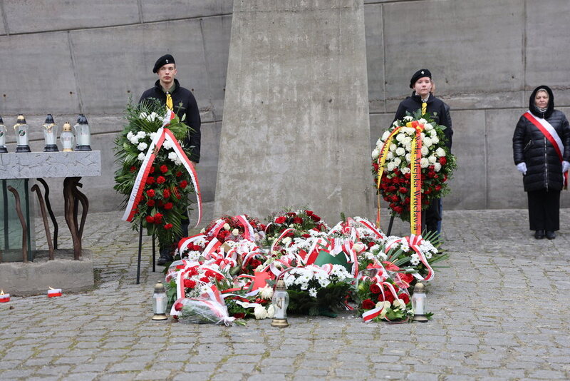 na zdjęciu warta honorowa ZHP na środku kwiaty pod pomnikiem