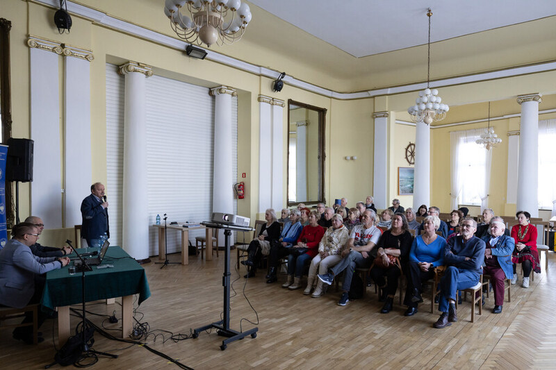 zdjęcie prezentuje widok na widownię wydarzenia, siedzących ludzi na krzesłach