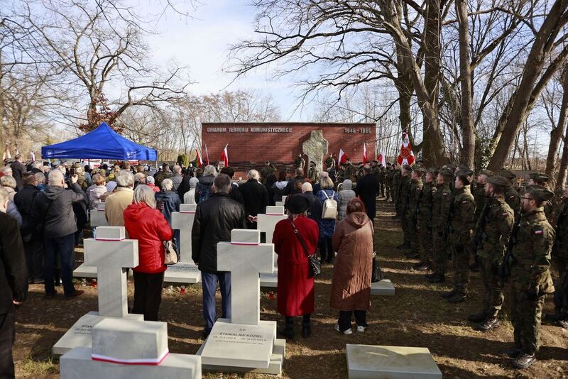 Zdjęcie z uroczystości. Panorama w tle pomnik, na pierwszym planie krzyże