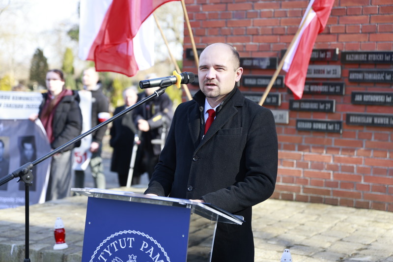 Zdjęcie z cmentarza, przy mównicy stoi Kamil Dworaczek