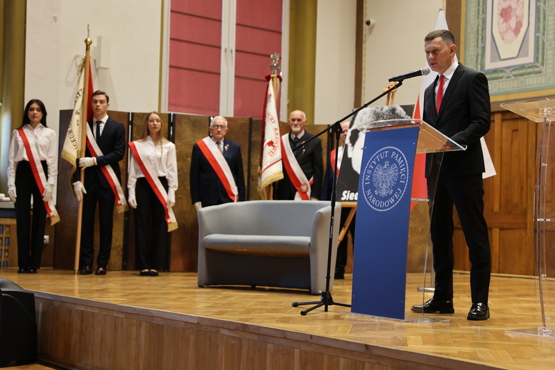 widok na scenie, na scenie stoi dyrektor szkoły przy mikrofonie