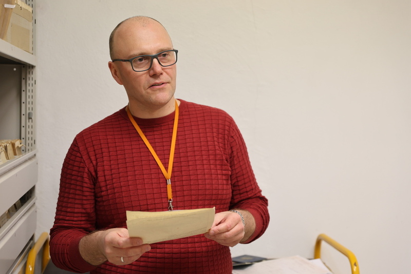 na pierwszym planie pracownik Archiwum mówiący o swojej pracy
