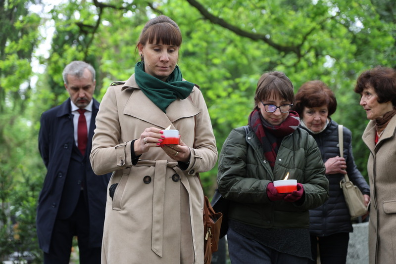 moment składania zniczy, na pierwszym planie diw kobiety