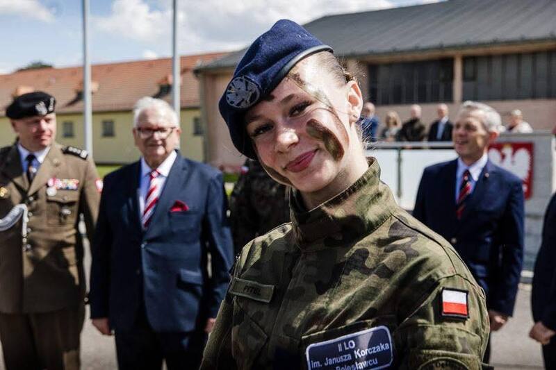 na zdjęciu dziewczyna w mundurze wojskowym uśmiechająca się do obiektywu