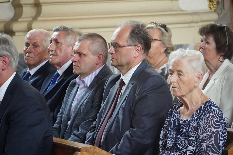 zbliższenie na ludzi siedzących w ławkach w kościele
