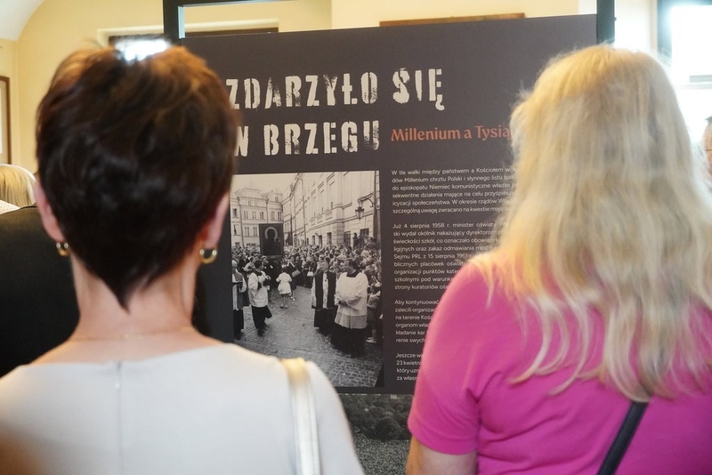 moment oglądania wystawy, przy planszach stoją ludzie