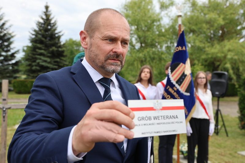 regionalista pokazuje do obiektywu tabliczkę instygdnium