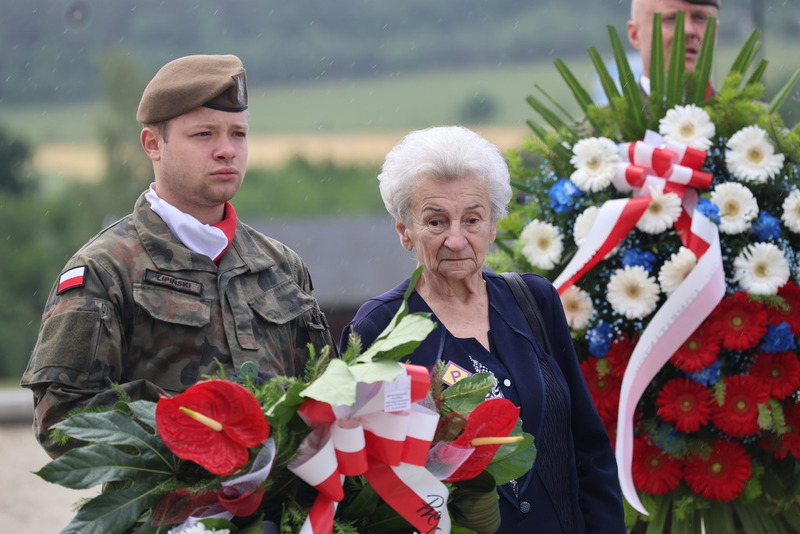 moment składania kwiatów, do pomnika podchodzi Leokadia Wieczorek