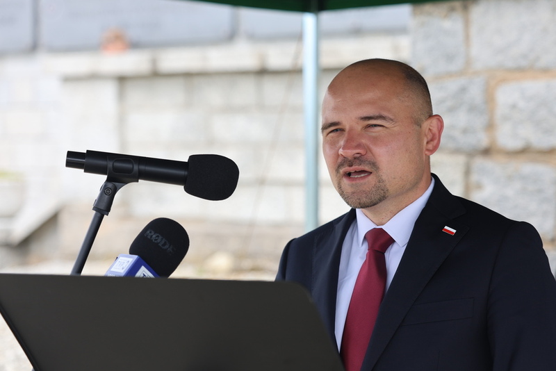 przy mikrofonie stoi Kamil Dworaczek i przemawia