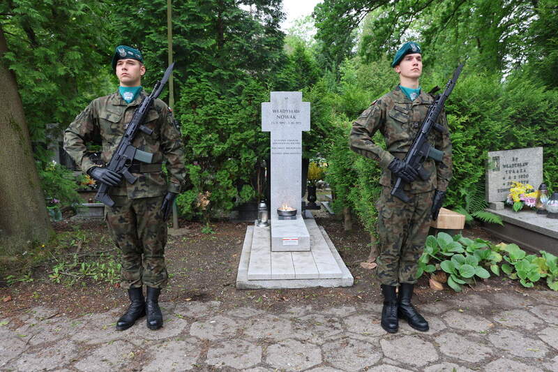 zdjęcie grobu po bokach stoi dwóch żołnierzy